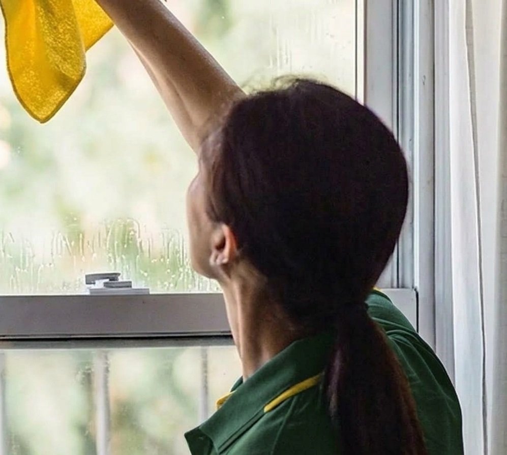 BrightHome cleaner wiping window glass, move out cleaning Houston